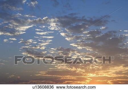 Stock Photograph - Sunset with puffy clouds. Fotosearch