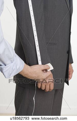 Tailor taking suit measurements View Large Photo Image Stock Image - Tailor taking suit measurements. Fotosearch