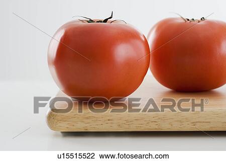 Tomatoes on cutting board View Large Photo Image Stock Image - Tomatoes on cutting board. Fotosearch