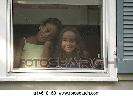 Two girls looking out a window View Large Photo Image Stock Image - Two girls looking out a window. Fotosearch