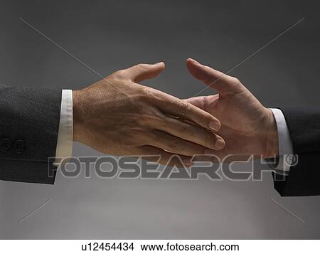 Picture - Two men about to shake hands. Fotosearch