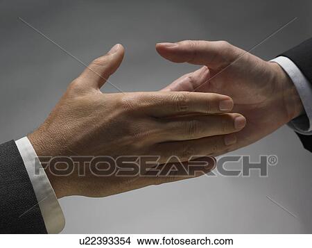 Picture - Two men about to shake hands. Fotosearch