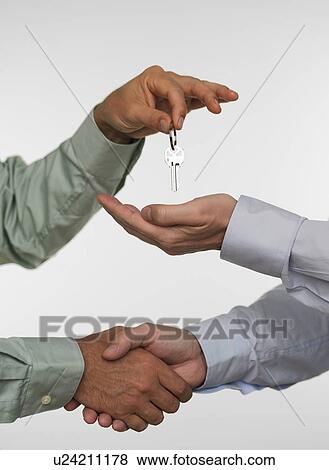 Two men closing deal and handing over keys View Large Photo Image Stock Photo - Two men closing deal and handing over keys. Fotosearch