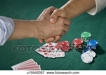 Two men shaking hands over poker game View Large Photo Image Stock Photo - Two men shaking hands over poker game. Fotosearch