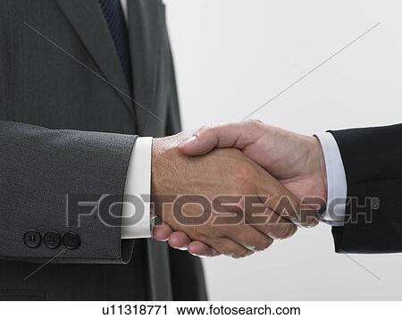Stock Image - Two men shaking hands. Fotosearch