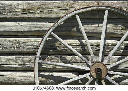 Stock Photo - Wagon wheel against wooden wall. Fotosearch