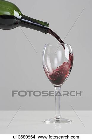 Picture - Wine pouring from bottle to glass. Fotosearch