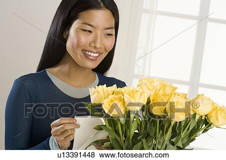 Stock Photo - Woman admiring bouquet of roses. Fotosearch