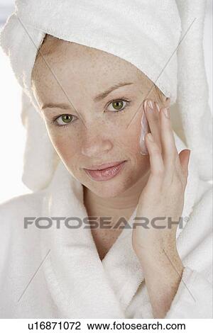 Stock Image - Woman applying face cream. Fotosearch