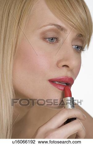 Woman applying red lipstick View Large Photo Image Stock Image - Woman applying red lipstick. Fotosearch