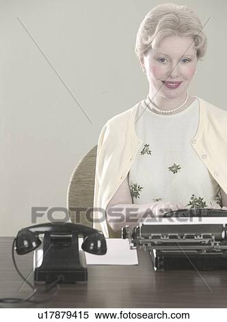 Stock Photography - Woman at desk with typewriter. Fotosearch