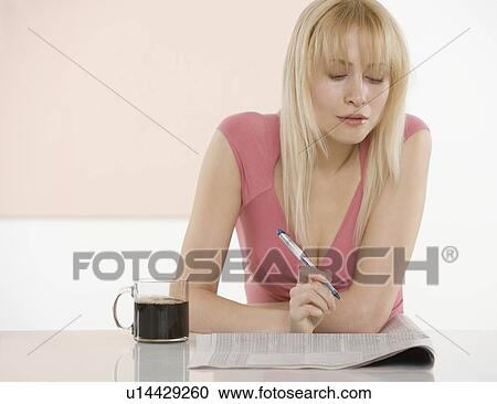 Woman at table with newspaper View Large Photo Image Stock Image - Woman at table with newspaper. Fotosearch