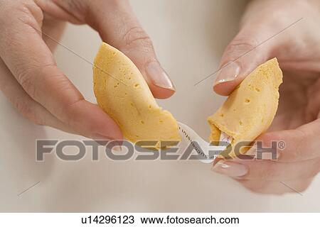 Stock Image - Woman breaking fortune cookie. Fotosearch