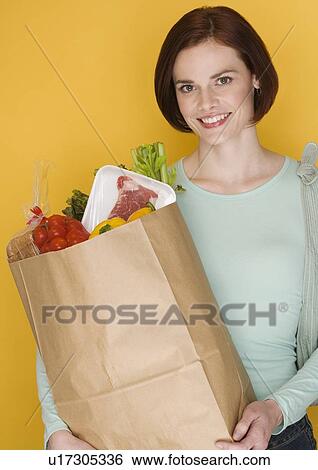 Stock Photograph - Woman carrying bag of groceries. Fotosearch