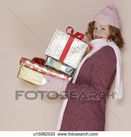 Woman carrying pile of presents View Large Photo Image Stock Image - Woman carrying pile of presents. Fotosearch