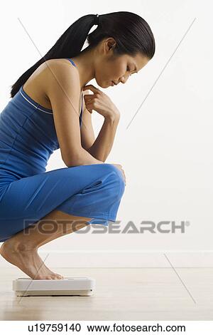 Woman checking weight on scale View Large Photo Image Stock Image - Woman checking weight on scale. Fotosearch