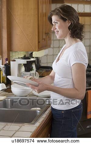Woman drying dish at kitchen sink View Large Photo Image Picture - Woman drying dish at kitchen sink. Fotosearch