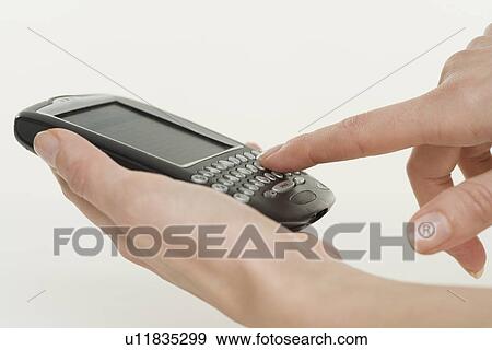 Woman holding a smart phone View Large Photo Image Stock Photo - Woman holding a smart phone. Fotosearch