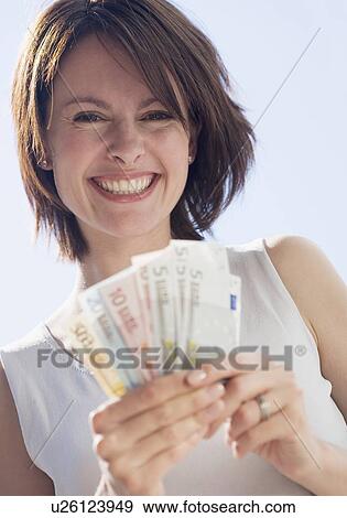 Stock Photo - Woman holding Euro bills. Fotosearch