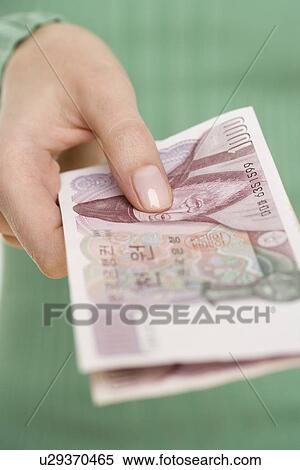 Woman holding Korean money View Large Photo Image Stock Photography - Woman holding Korean money. Fotosearch