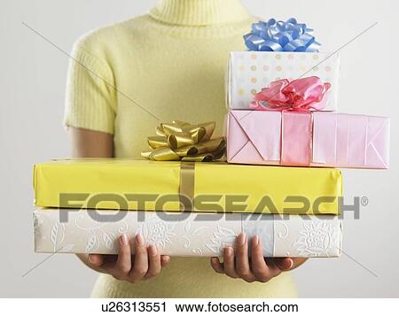 Woman holding pile of presents View Large Photo Image Stock Image - Woman holding pile of presents. Fotosearch