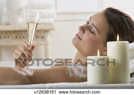 Stock Image - Woman in bathtub with champagne. Fotosearch