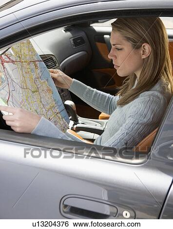 Woman in car looking at a map View Large Photo Image Stock Photograph - Woman in car looking at a map. Fotosearch