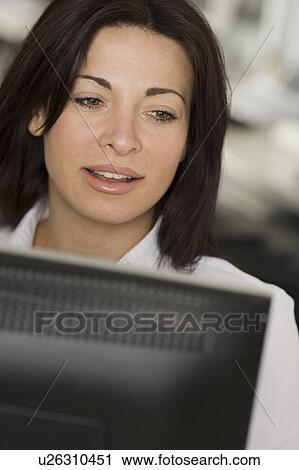 Woman in office looking at computer screen View Large Photo Image Stock Image - Woman in office looking at computer screen. Fotosearch