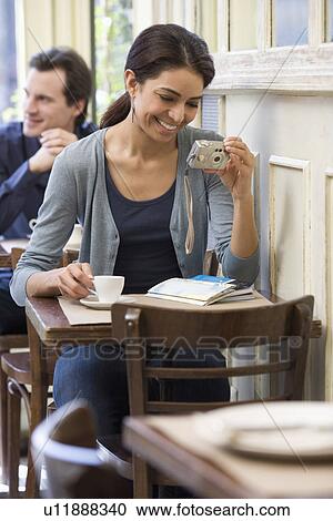 Woman looking at digital camera in restaurant View Large Photo Image Stock Image - Woman looking at digital camera in restaurant. Fotosearch