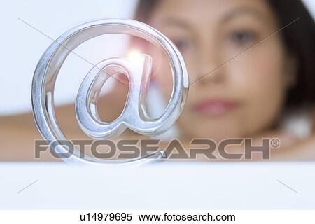 Woman looking at metal @ symbol View Large Photo Image Stock Photography - Woman looking at metal @ symbol. Fotosearch
