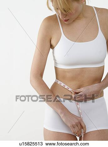 Woman measuring her waist View Large Photo Image Stock Image - Woman measuring her waist. Fotosearch