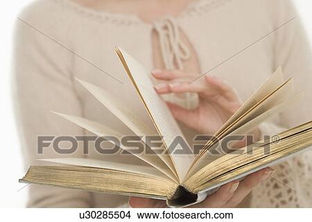 Woman paging through a book View Large Photo Image Picture - Woman paging through a book. Fotosearch