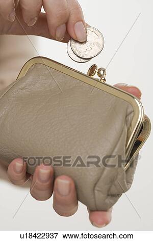 Stock Photo - Woman putting change in coin purse. Fotosearch