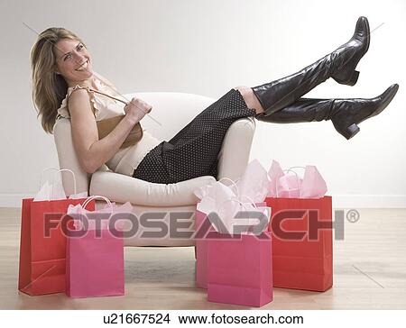 Picture - Woman relaxing after shopping. Fotosearch