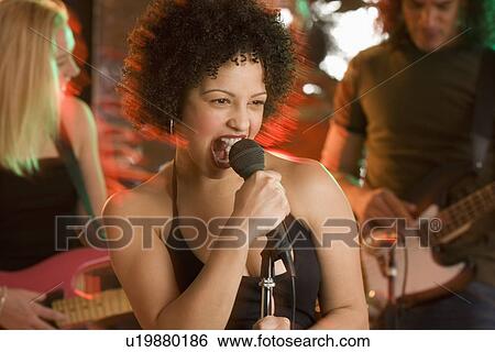 Stock Photograph - Woman singing with a band. Fotosearch
