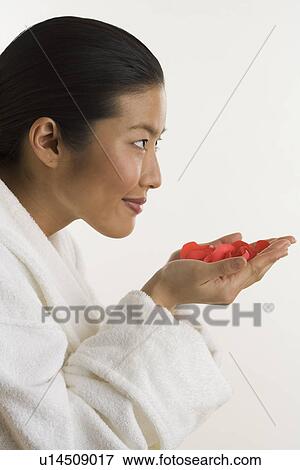 Stock Photo - Woman smelling rose petals. Fotosearch
