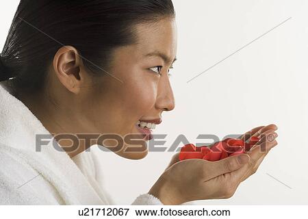 Stock Photo - Woman smelling rose petals. Fotosearch