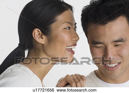 Stock Photograph - Woman telling man a secret. Fotosearch