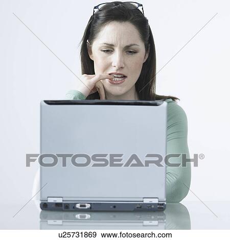 Stock Photo - Woman thinking with laptop. Fotosearch