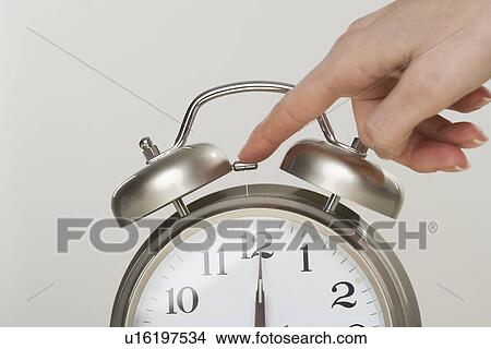 Picture - Woman turning off alarm clock. Fotosearch