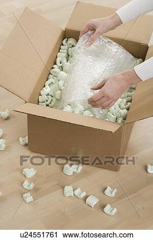 Stock Image - Woman unpacking a box. Fotosearch