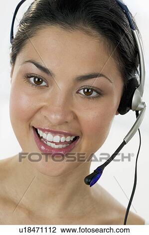 Stock Image - Woman using a headset. Fotosearch