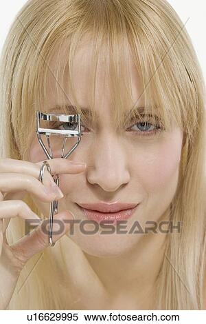 Woman using eyelash curler View Large Photo Image Stock Photography - Woman using eyelash curler. Fotosearch