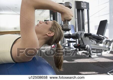 Stock Photo - Woman using free weight. Fotosearch