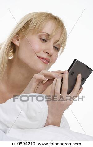 Woman using PDA in bed View Large Photo Image Stock Photo - Woman using PDA in bed. Fotosearch