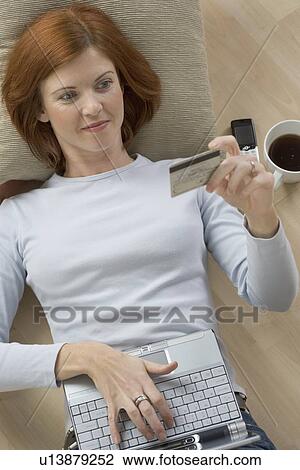 Stock Image - Woman with computer and credit card. Fotosearch