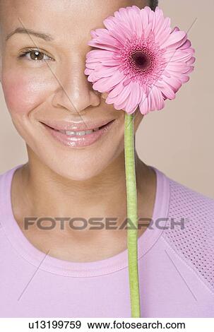 Woman with flower over one eye View Large Photo Image Stock Photo - Woman with flower over one eye. Fotosearch