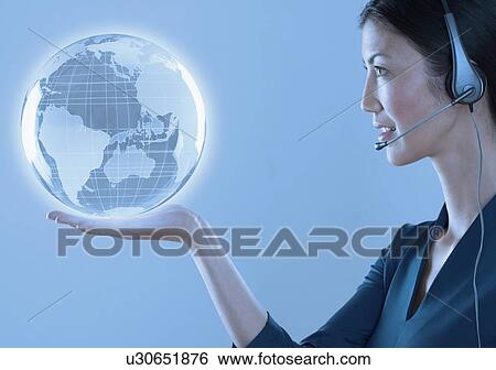 Stock Photograph - Woman with headset holding a globe. Fotosearch