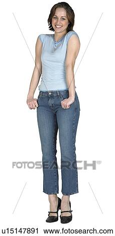 Stock Image - Woman with her thumbs in her pockets. Fotosearch