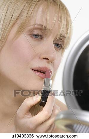 Woman with mirror applying lipstick View Large Photo Image Stock Photograph - Woman with mirror applying lipstick. Fotosearch